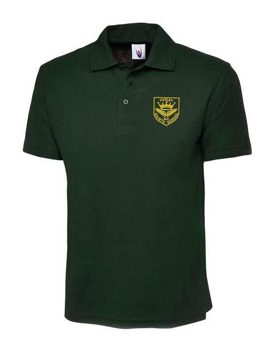 Dark green polo shirt featuring a yellow embroidered emblem on the left chest area. The emblem has text and a graphic. The shirt has short sleeves and a buttoned collar.